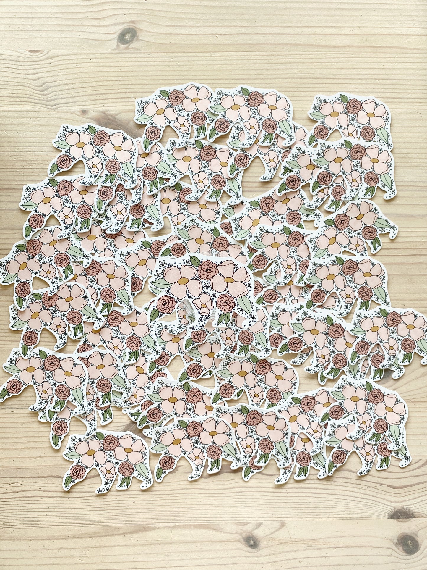 A grouping of mama bear floral silhouette stickers spread out on a table with one sticker featured in the centre of the image.