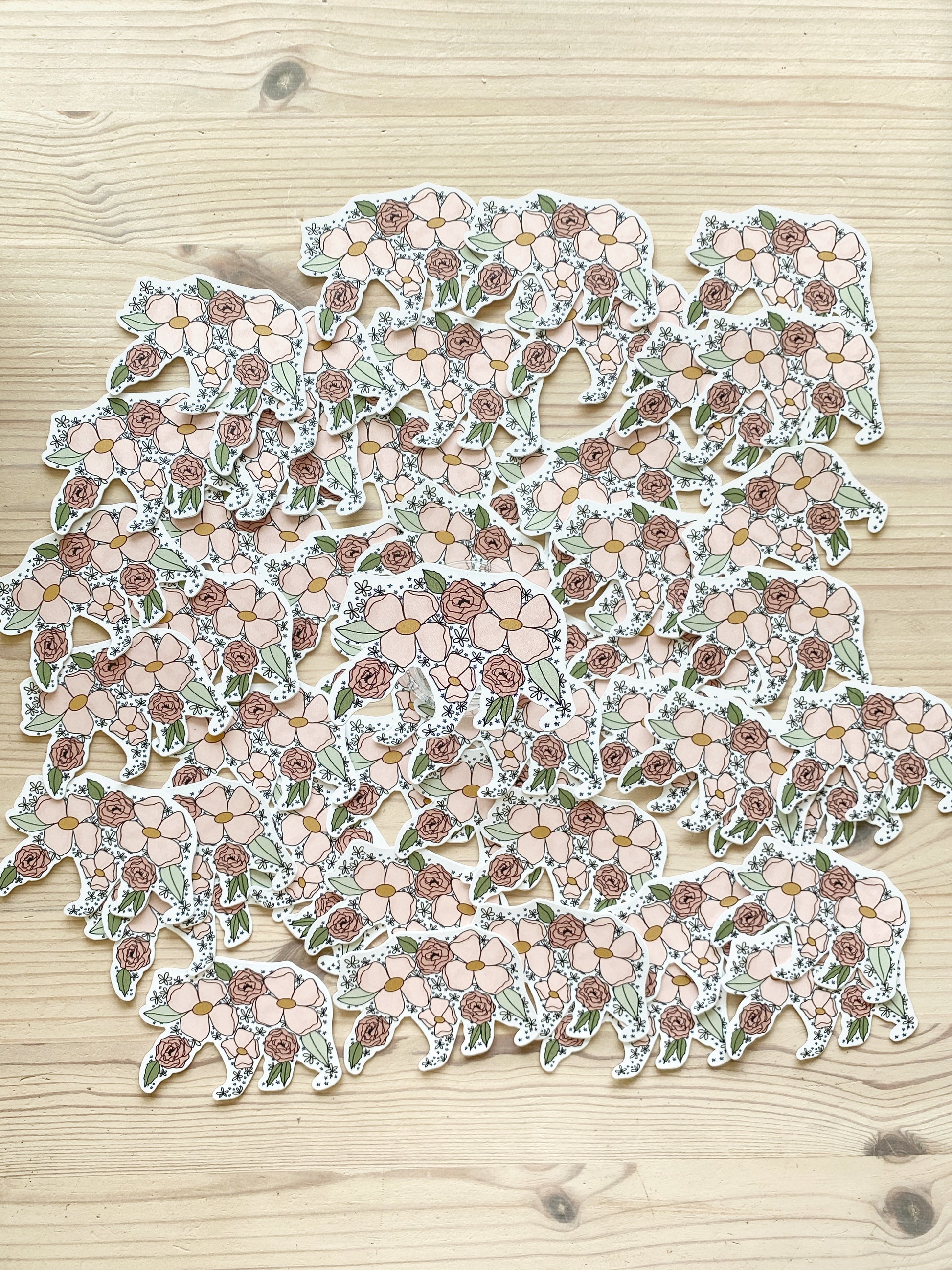 A grouping of mama bear floral silhouette stickers spread out on a table with one sticker featured in the centre of the image.