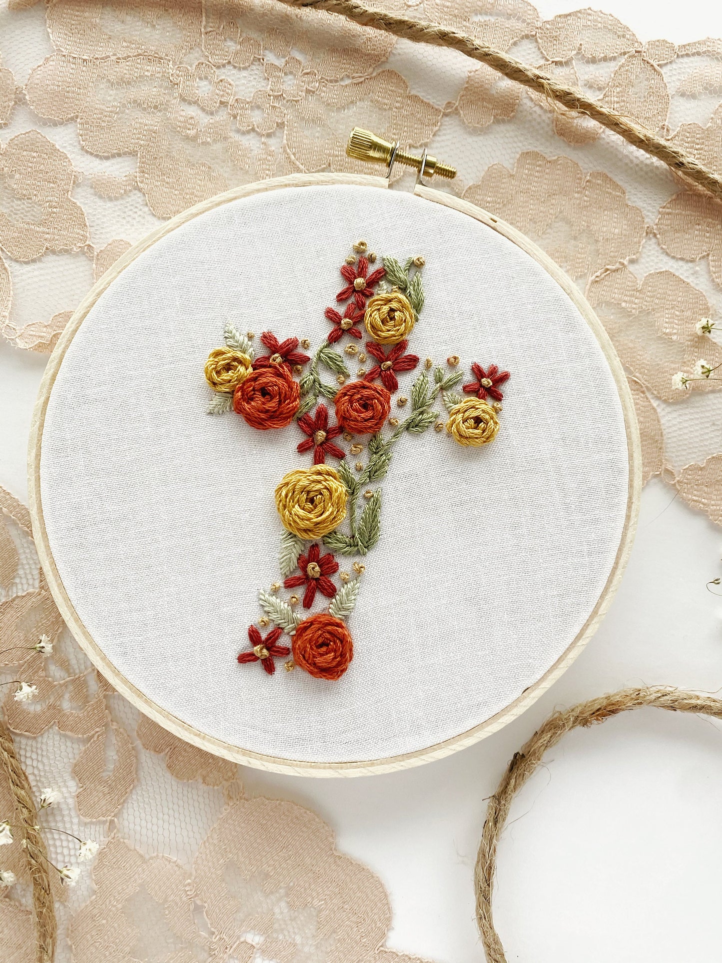 A close up of floral embroidery cross design displayed artfully for inspiration in embroidery projects.